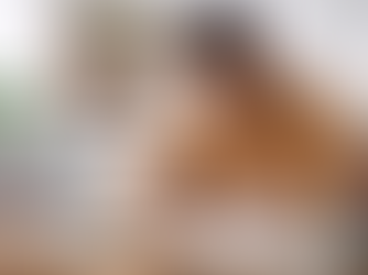 Estudante negro estuda em casa, sentado à mesa com livros abertos, caderno e computador, em ambiente organizado e iluminado.