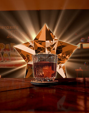 A dark-orange cocktail with an orange heart garnish at its core. A bright garnet star scorches from behind it.