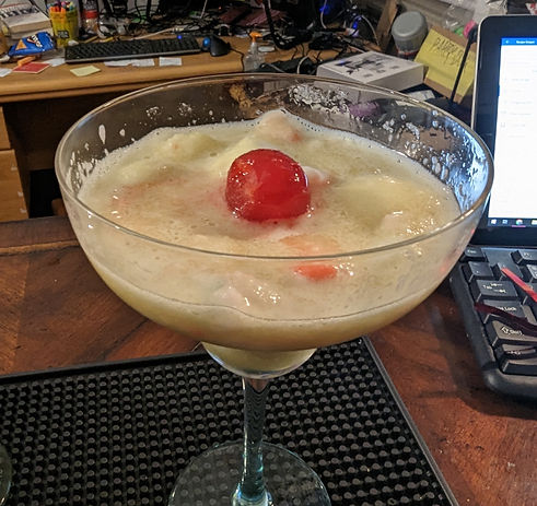 An icy green colored semi-fluid that appears to be buoyantly supporting a single maraschino cherry. They say that pieces of the famous Titanic may be found somewhere ate the bottom of the glass...
