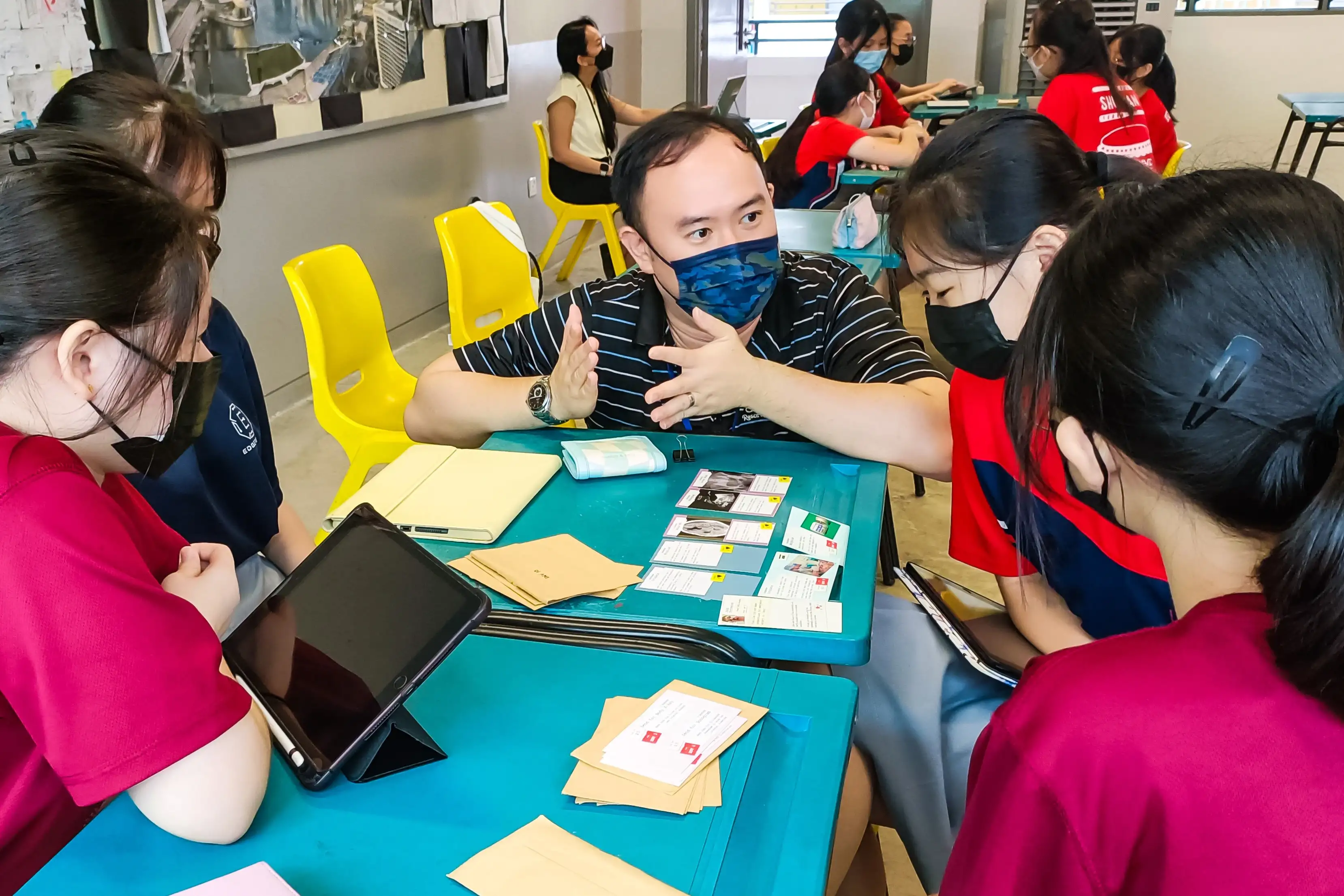 A healthcare professional talking with students in smaller groups.