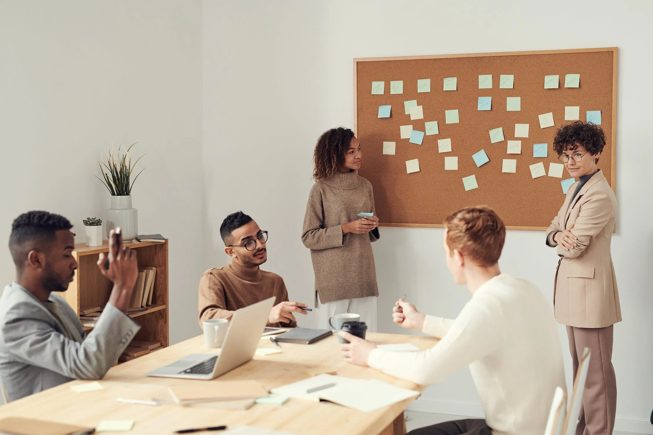 A diverse group of writers brainstorming, writing, or discussing ideas in a collaborative workspace.