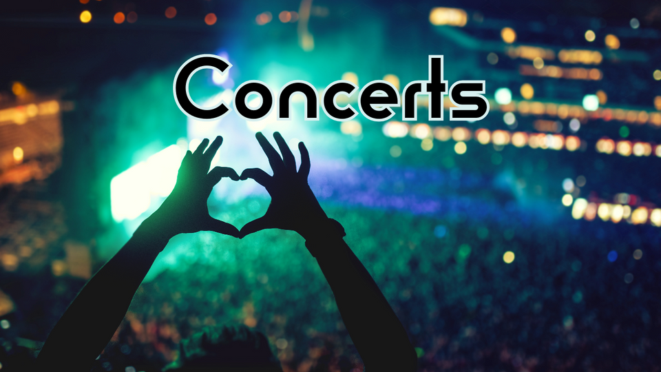 A large live event with a person making a heart symbol with their hands