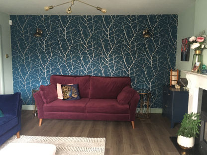 Cosy living room with wooden floor and burgandy sofa