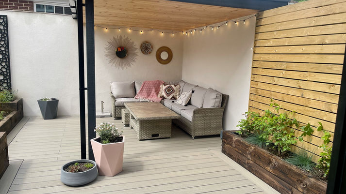 Outside sofa area with pale decking and wooden panelling
