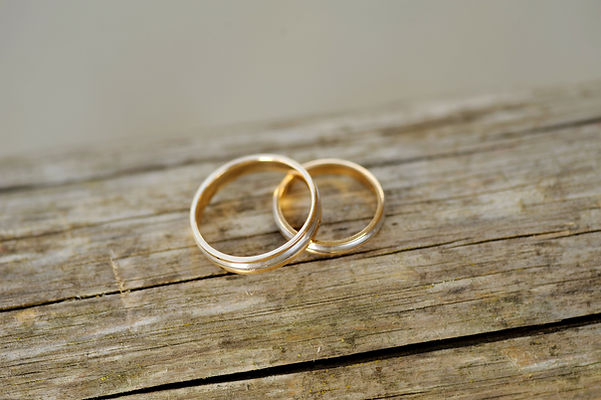 Cinematic wedding videography in Belgrade, MT by Tay-Rae Productions - Wedding rings on rustic wood background.
