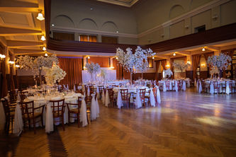 Svadobná výzdoba vo Veľkej Dvorane v Ružomberku bola ukážkou toho, ako môže aj veľká sála pôsobiť elegantne, luxusne a harmonicky. Dominantným prvkom sa stali naše kvetinové a čerešňové stromy, ktoré pôsobili majestátne, no zároveň jemne dopĺňali atmosféru priestoru.

Celkový vzhľad sme podčiarkli čírymi a zlatými dekoráciami, doplnili sme živé kvety a postarali sa o decentné osvetlenie, ktoré vytvorilo čarovnú svadobnú atmosféru. Kombinácia výškových dekorácií, detailne prepracovaných prvkov a kvalitných materiálov premenila sálu na priestor, ktorý pôsobil sviežo, nadčasovo a premyslene.

Naše kvetinové a čerešňové stromy sú ideálnym riešením pre veľké sály, kde dodajú luxus a vzdušnosť. Sú vhodné ako výzdoba hlavného stola, doplnok ku kruhovým stolom hostí alebo ako výrazná dominanta v priestore.

Ak plánujete svadbu vo väčšej sále, aj tá môže pôsobiť exkluzívne. Radi pre vás pripravíme návrh svadobnej výzdoby na mieru – od Ružomberka, cez Námestovo a Dolný Kubín až po celý Žilinský kraj.