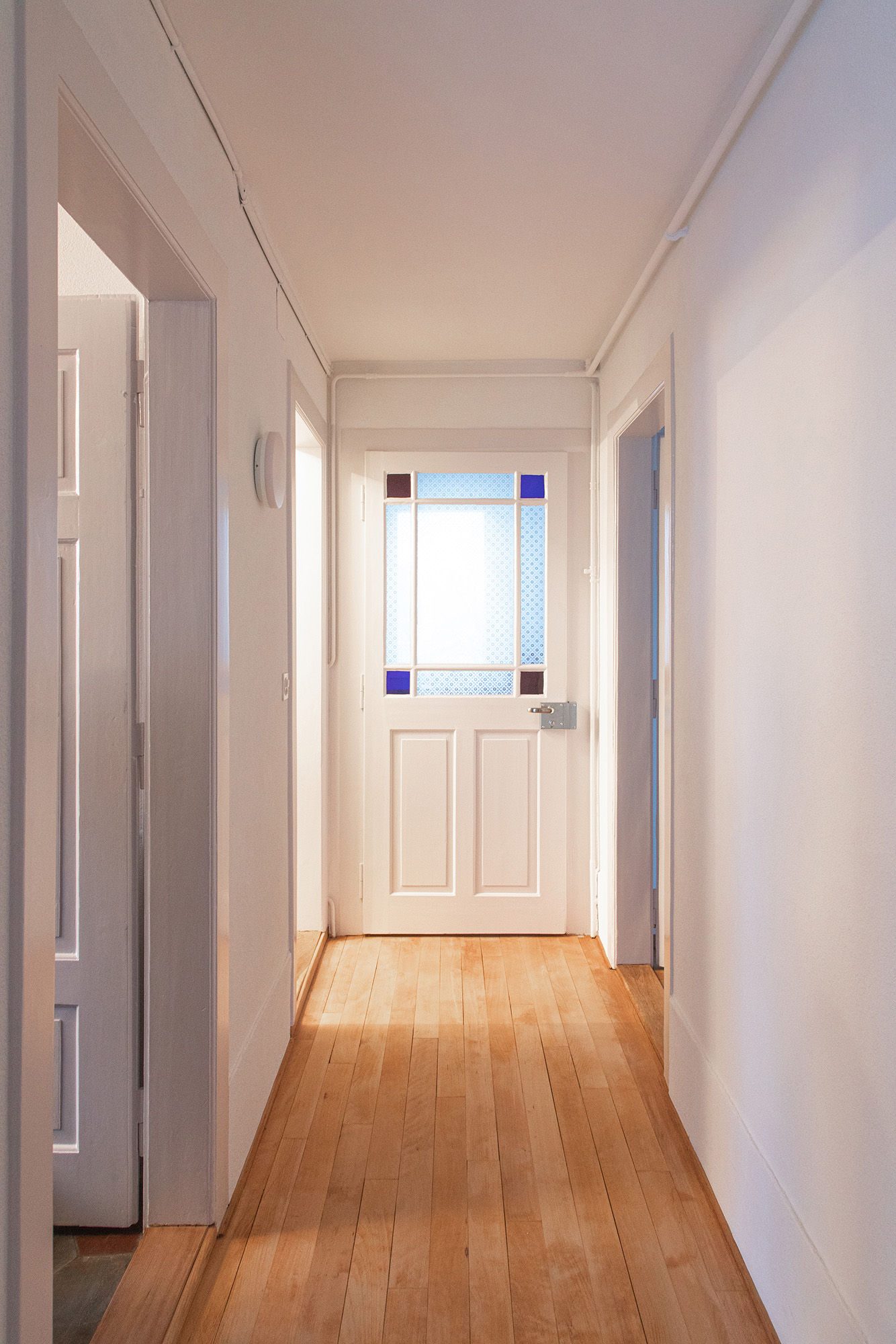 Fotografie mit Blick in den Korridor einer Dachwohnung mit schönem Parkettboden.