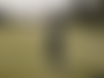 Golfer after taking a swing on a golf tee box looking down the fairway.