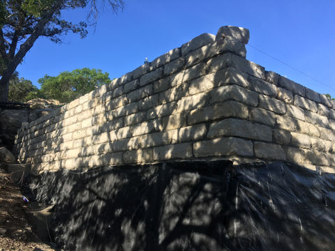 Stone retaining wall for cliffside concrete foundation on Lake Travis