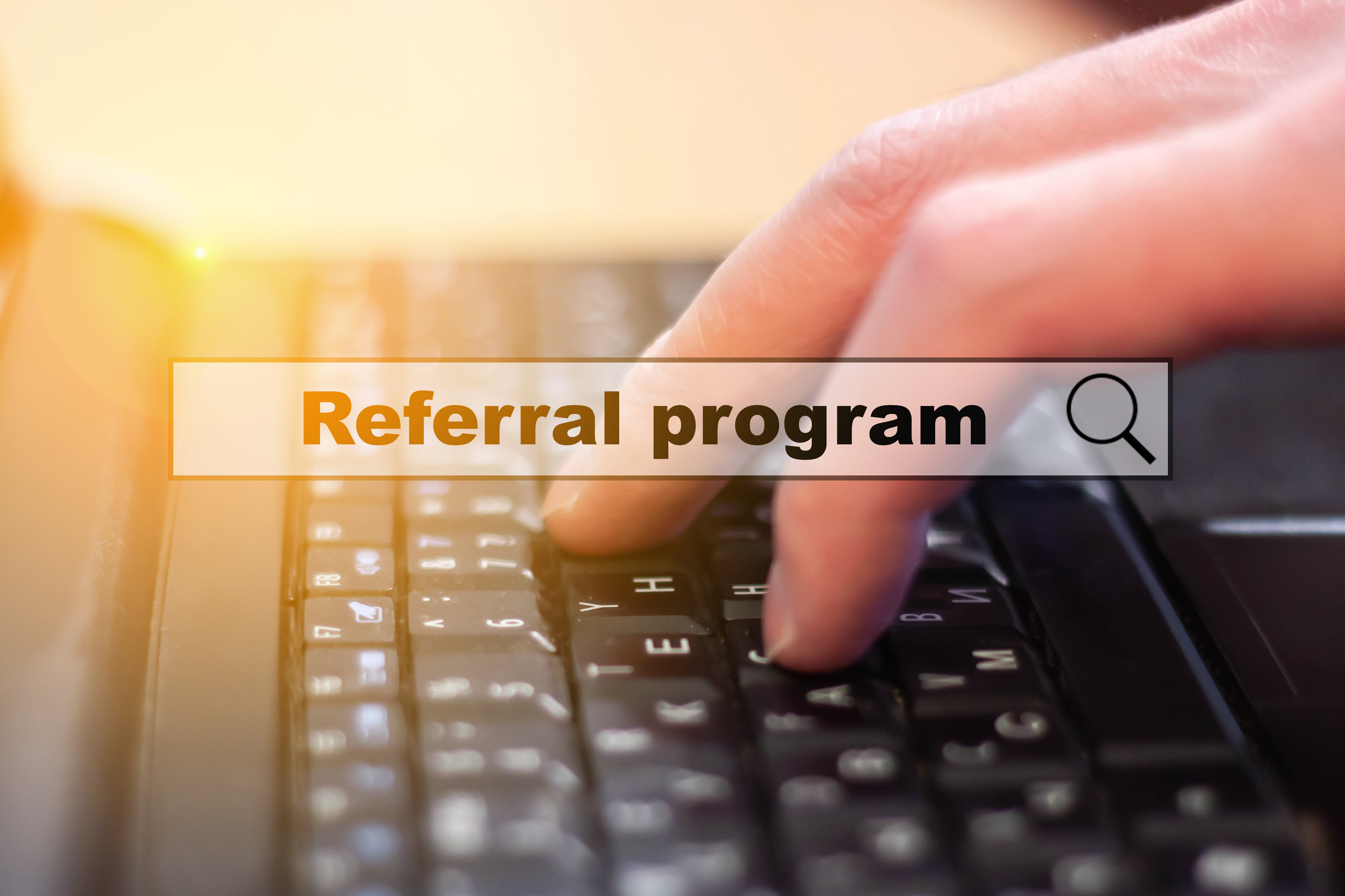 Imagine of someone typing with the text Referral Program