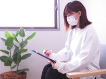 こやま整骨院の施術室にて、カウンセリングシートを記入している様子の画像