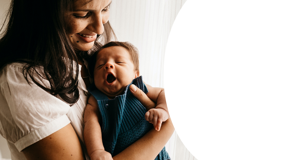 woman smiling while holding yawning baby