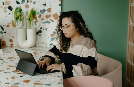 woman typing using a tablet on a colorful table