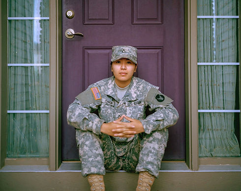 asian woman in u.s. military uniform sitting on porch
