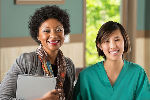 African American counselor and Asian nurse smiling.