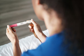 Woman looking at a positive pregnancy test.