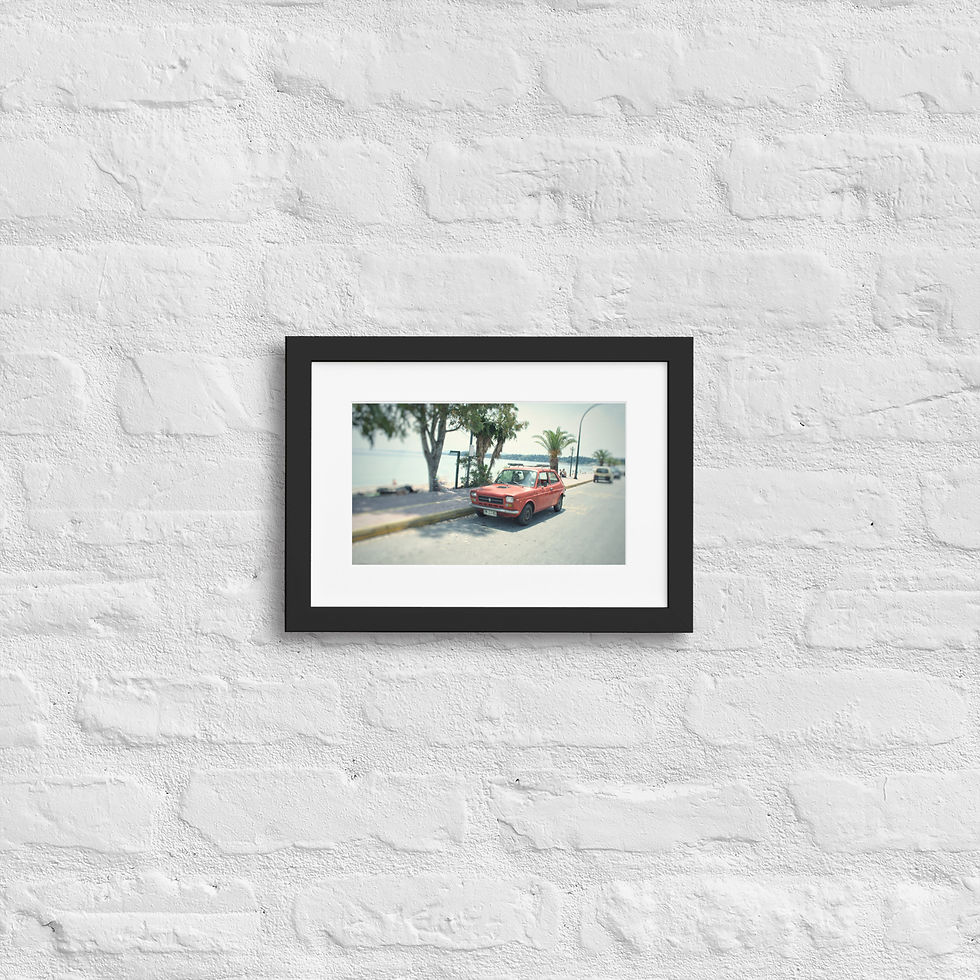 Retro street photography featuring a classic small red Fiat or similar European car by the waterfront.