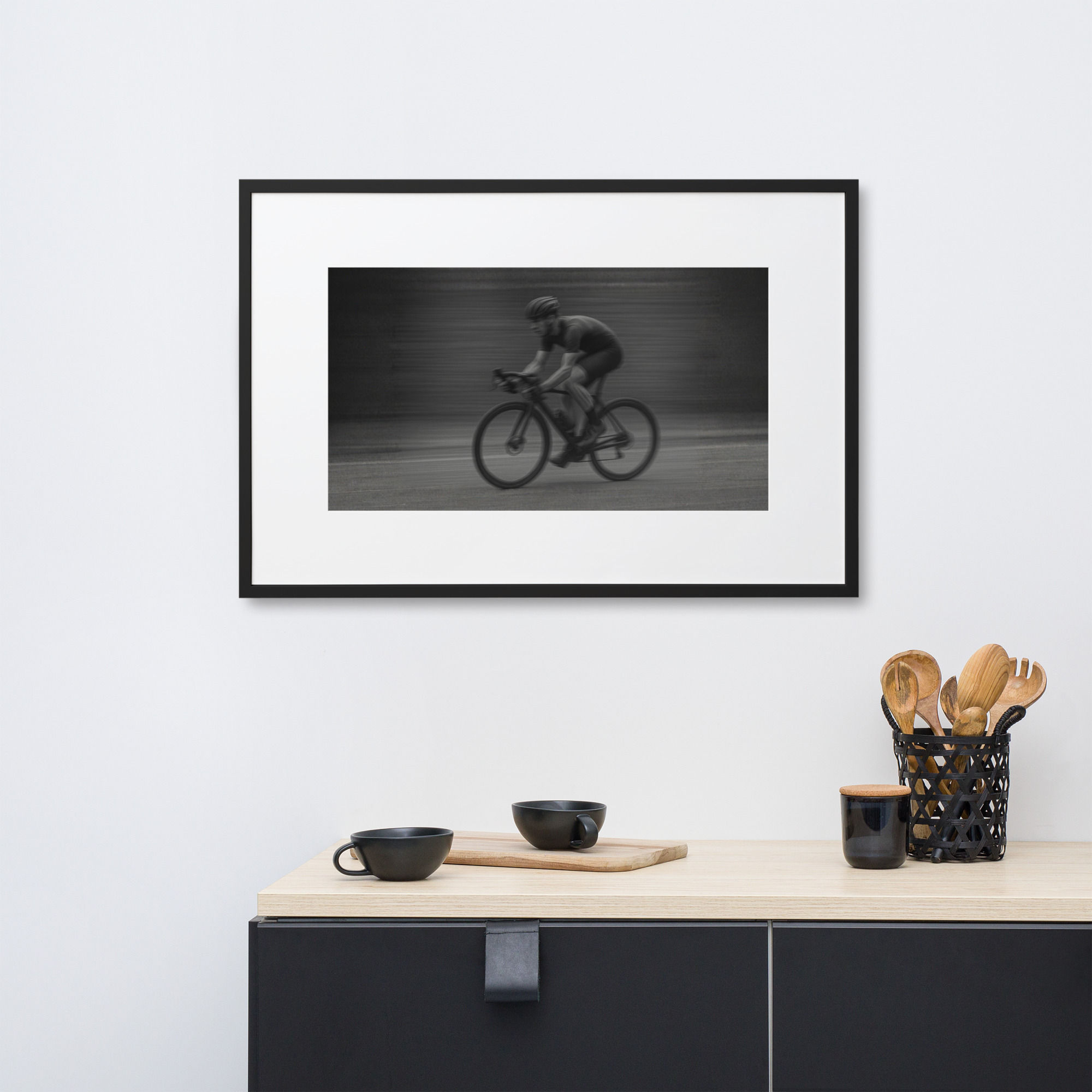 Framed black and white photo of a time trial cyclist riding a bike with motion blur, emphasizing speed and focus.