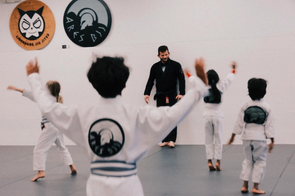Children practicing Brazilian Jiu Jitsu under instructor supervision at Liberdade BJJ.