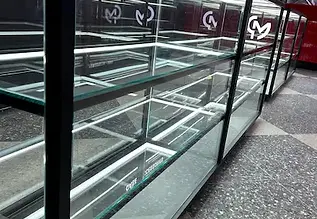 Meticulously wiped and dust-free glass display cabinets positioned on a newly laid aggregate terrazzo floor inside a premium retail store fit-out handover clean at Westfield Southland.