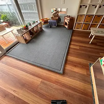 Pristine timber flooring and a deep HEPA-extracted play area rug inside a premium St Kilda early learning centre, fully inspected and logged to meet 2026 NQF Quality Area 2 hygiene standards.