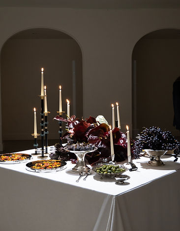 Elegant buffet table with grapes and candles – immersive scenography for The Oblist event