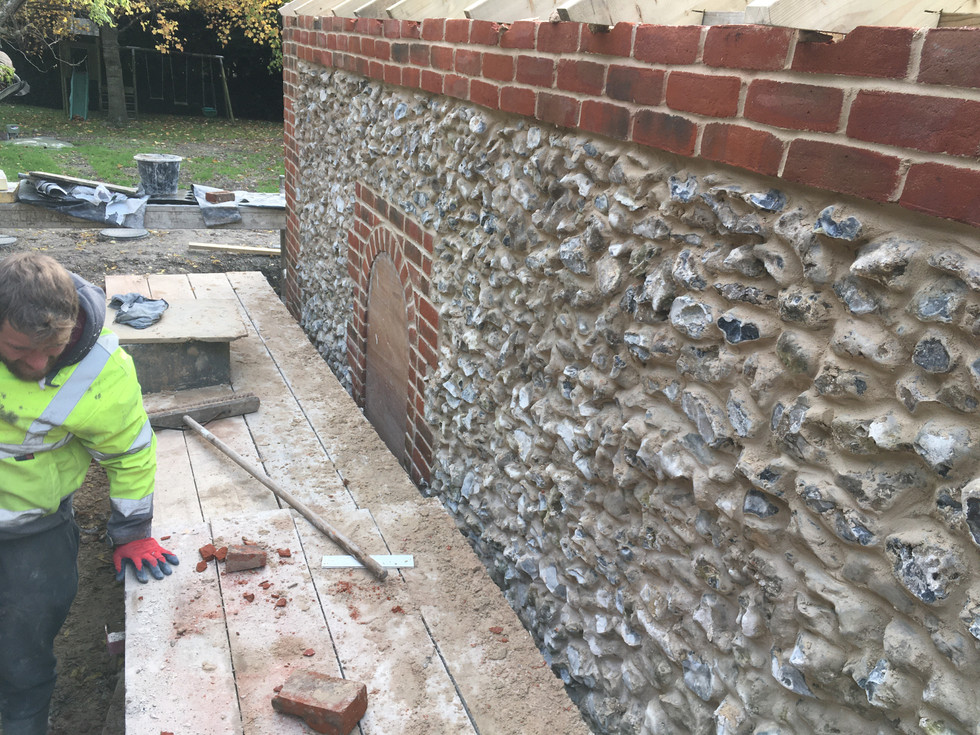 locally sourced hampshire flint stone and reclaimed red bricks for corner detail and archway windows