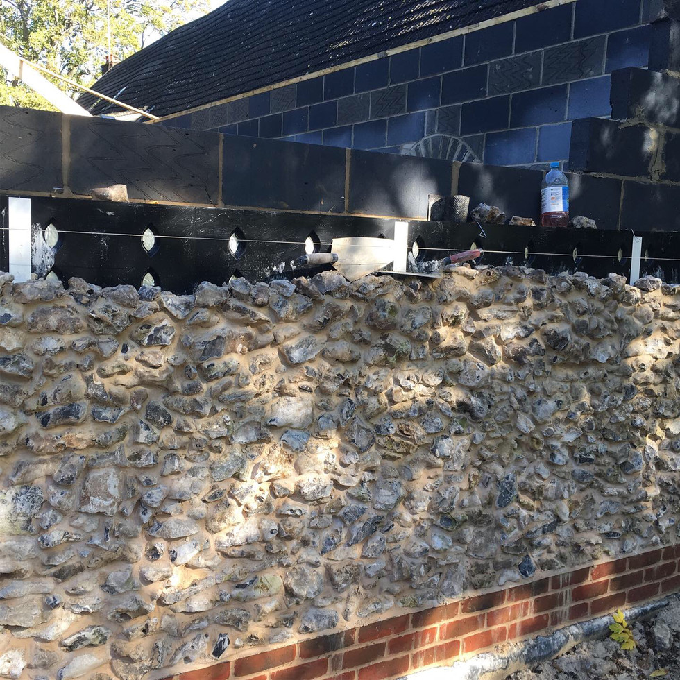 local sourced flint stone wall and red brick coins at barn build in hampshire