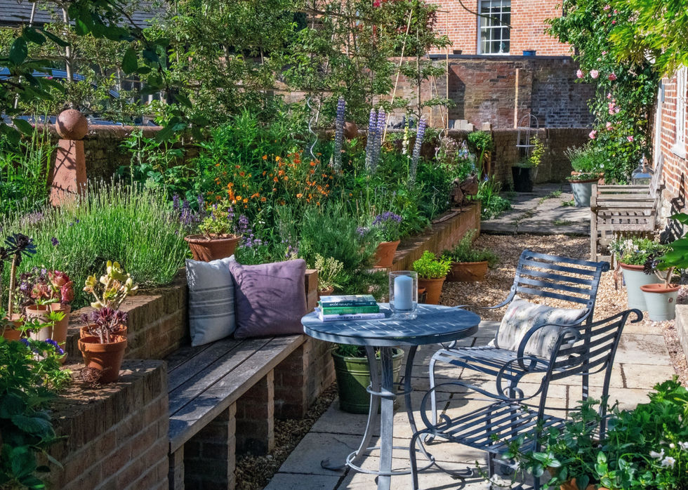 Outdoor dining area with seating bench built into retaining wall with