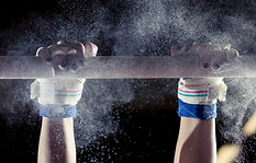 hands of gymnast with chalk on uneven ba