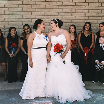 brides taking a photo with their wedding party