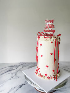 red and white cake with red bows and mini red hearts and sprinkles for a womans 30th birthday Sydney cakes Sutherland shire cakes gluten free cake