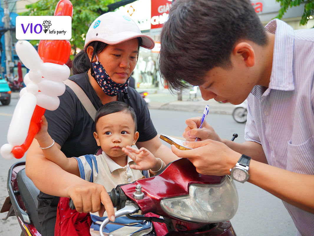 Phụ huynh được nhân viên Nha khoa hỗ trợ ghi thông tin, còn các bé thì thích thú nhận quà bong bóng từ chú hề Vioparty
