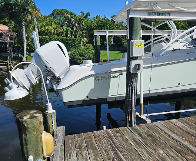 Boat positioned on a lift while receiving dockside marine maintenance service.