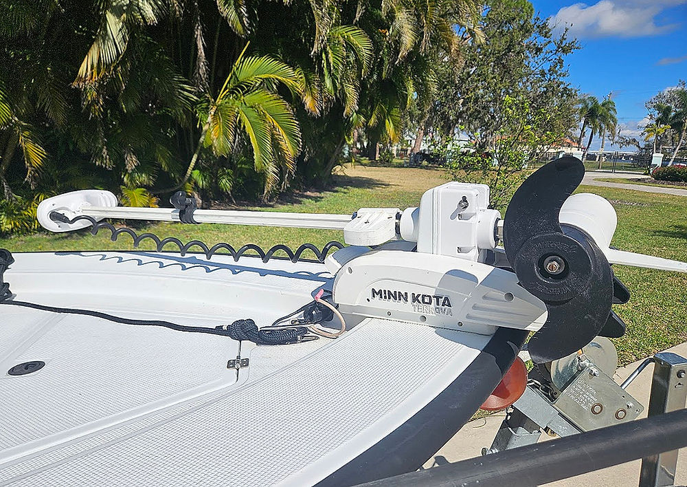 White Minn Kota Terrova electric trolling motor with propeller mounted on the bow of a white boat.