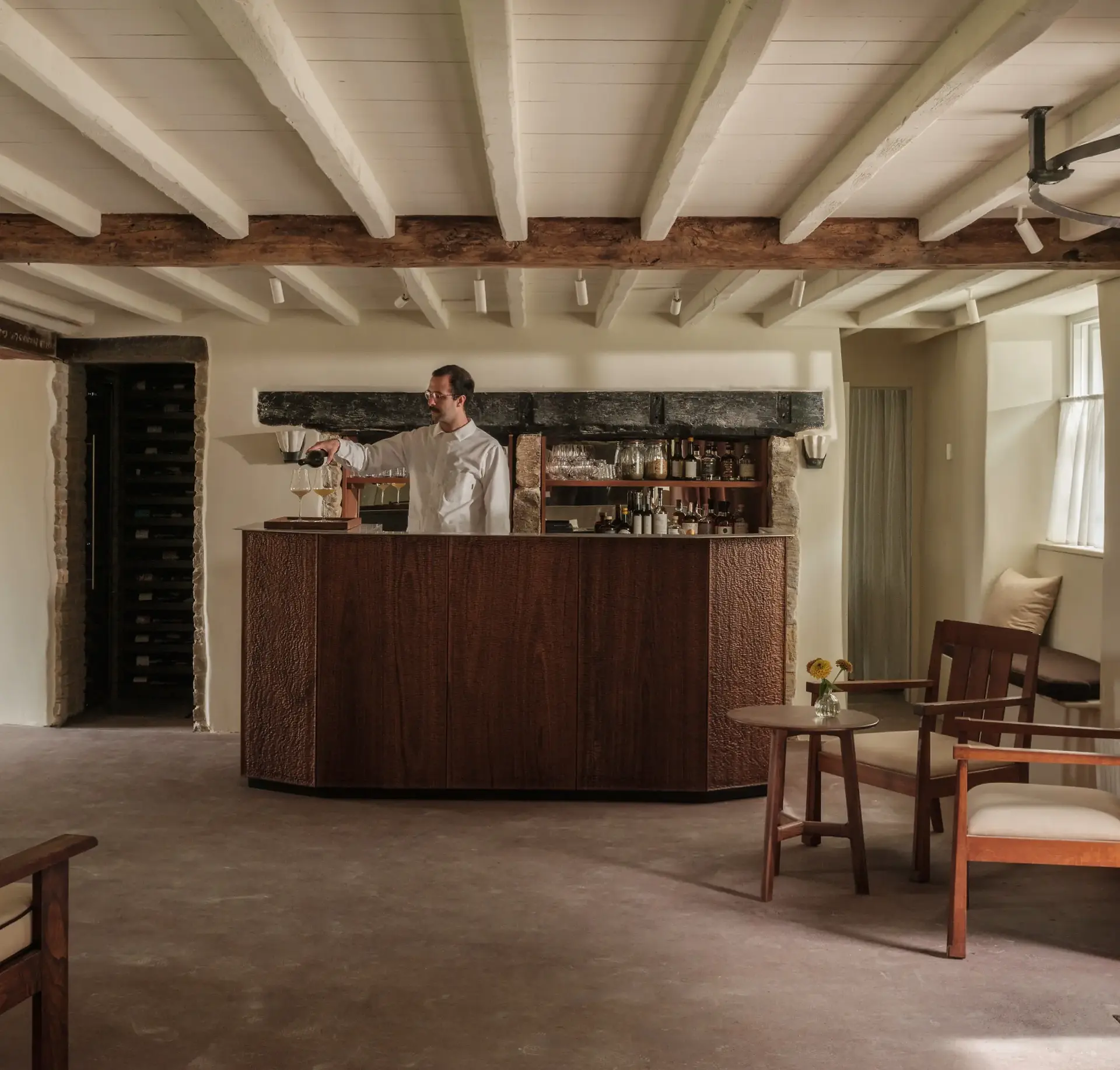 Rustic bar and lounge area with exposed wooden beams and fireplace