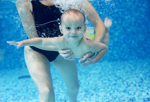 little-boy-learning-to-swim-in-a-swimming-pool-2021-08-26-22-40-03-utc.webp