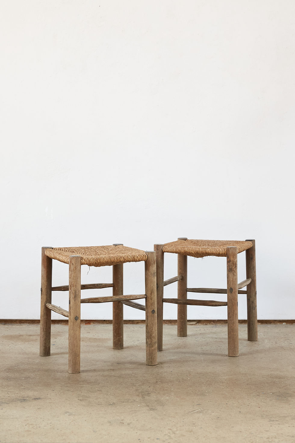Thumbnail: A matching pair of early 20th-century French wooden stools with woven rush seats.