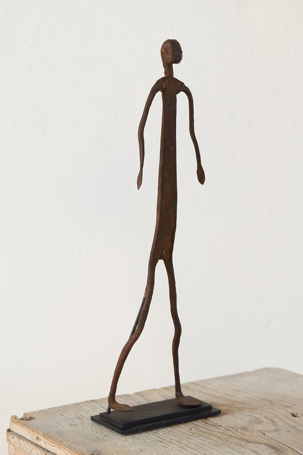 Two sculptural mid-century Dogon iron figures from Mali, now mounted on stands for display.