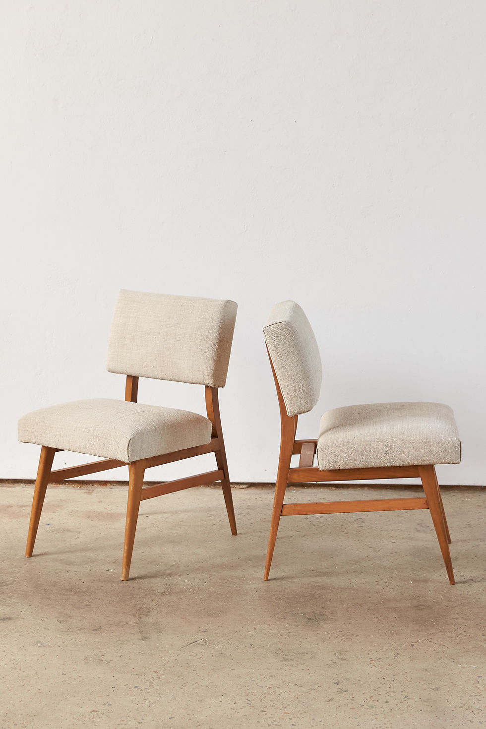 Thumbnail: A pair of French mid-century chairs dating from around 1950, with elegant wooden frames and generously proportioned seats and