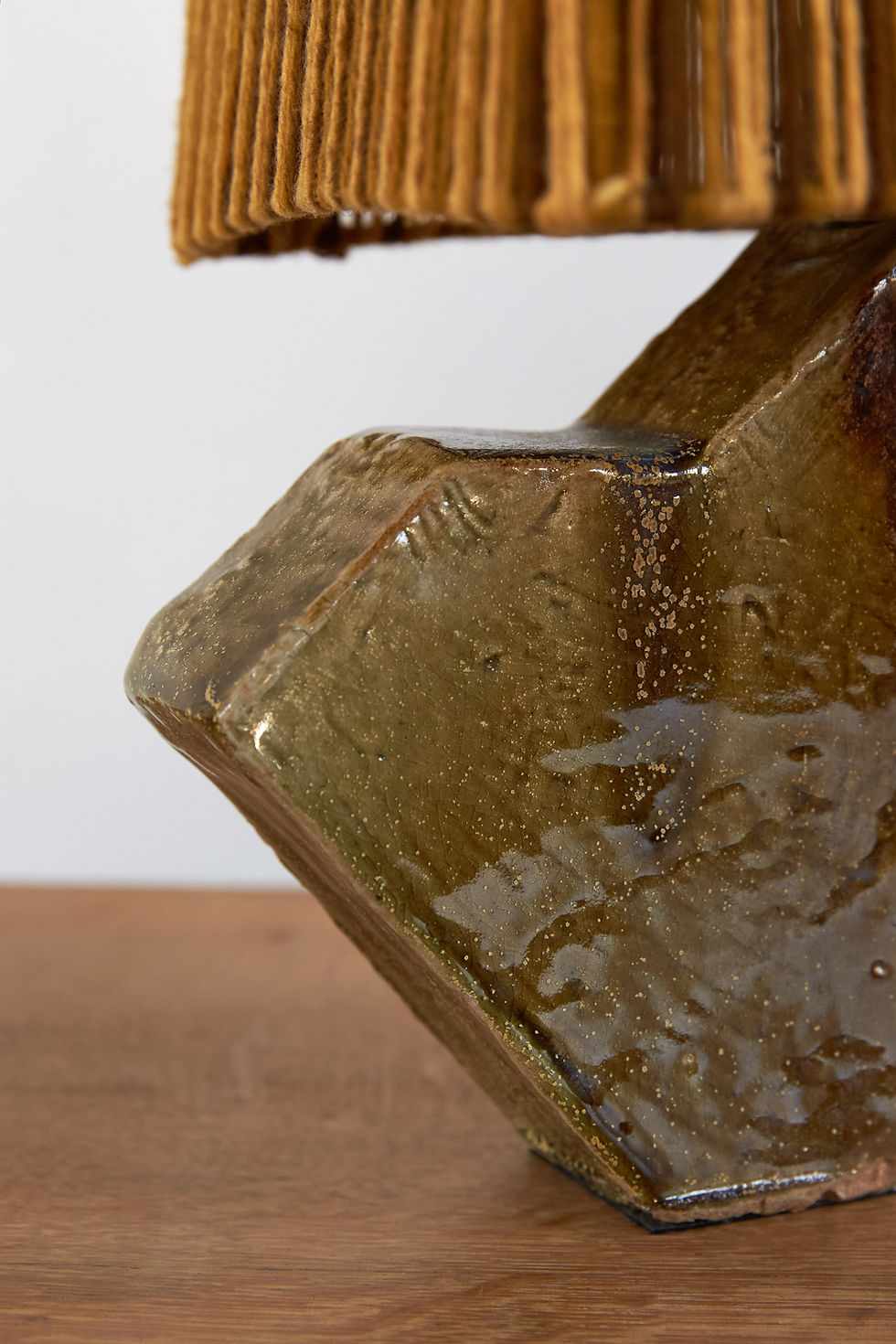 Thumbnail: A French studio pottery table lamp with a faceted geometric base finished in a rich olive green and brown glaze, C1970.