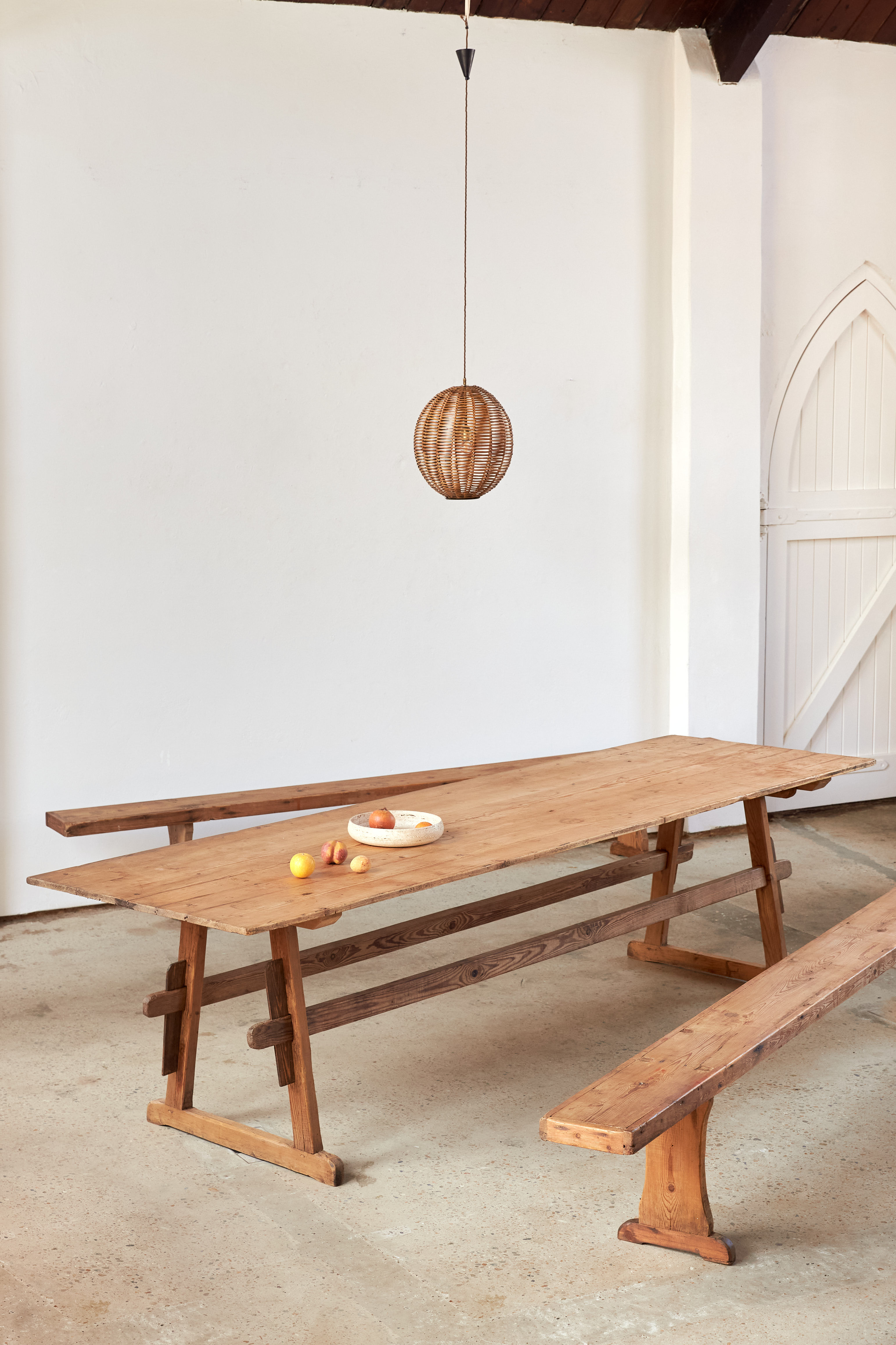 A large-scale 19th-century pine trestle table from the Southern Tyrol, with two matching benches.