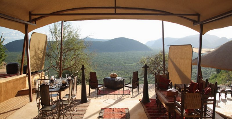 Guest area with chairs overlooking the Samburu safari reserve through an open sided permanent tent at Saruni Samburu Safari Lodge in Samburu, Kenya