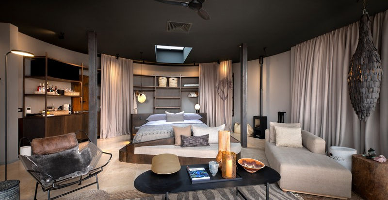 Large guest suite with double bed, sofa, coffee table and a bar at Sossusvlei Desert Lodge in Sossusvlei in Namibia