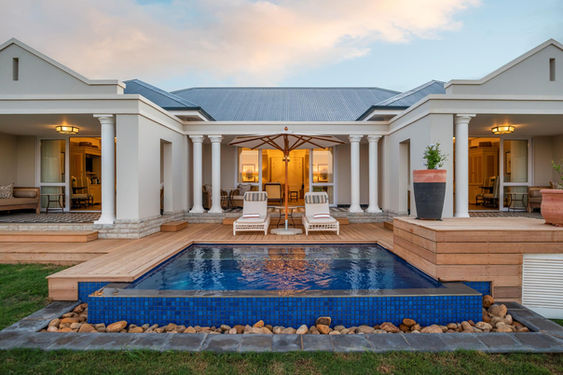 Long Lee manor swimming pool with deck and two long chairs