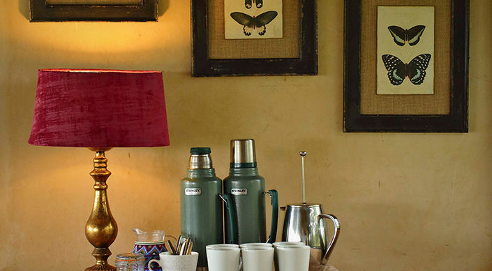Tea and Coffee station showing cups and flasks with a lamp and 3 paintings on the wall at Ol Pejeta Bush Camp in Laikipia in Kenya with Safari Ambitions