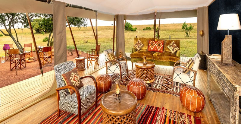 Main open sided guest area with sofas, tables and chairs overlooking the deck and view at Saruni Wild Camp in The Greater Masai Mara, Kenya