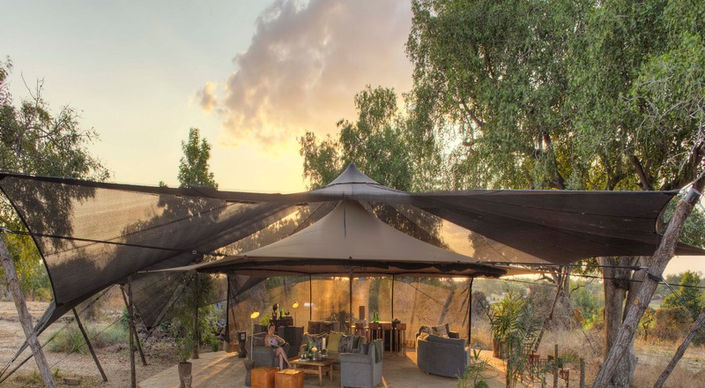 Main guest area at sunset with sofas and deck at Roho ya Selous Safari Camp in Nyerere National Park in Tanzania with Safari Ambitions