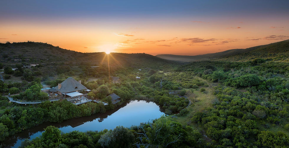 Sunset over a river and trees with a lodge on the side of the river