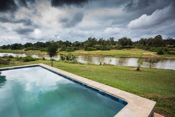 Swimming pool in front of the grassy bank and Olifants River